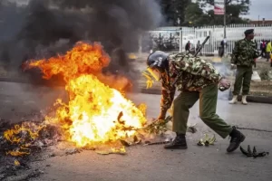 A Military police officer trying to put out fire set on the road